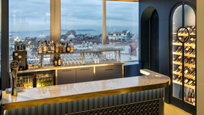 Un bar con vistas a la ciudad, una bodega y una grifería de cerveza.
