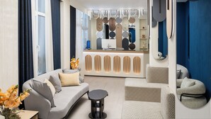 Una sala de estar moderna con un sofá, una mesa de centro y una zona de estar con cojines estampados.