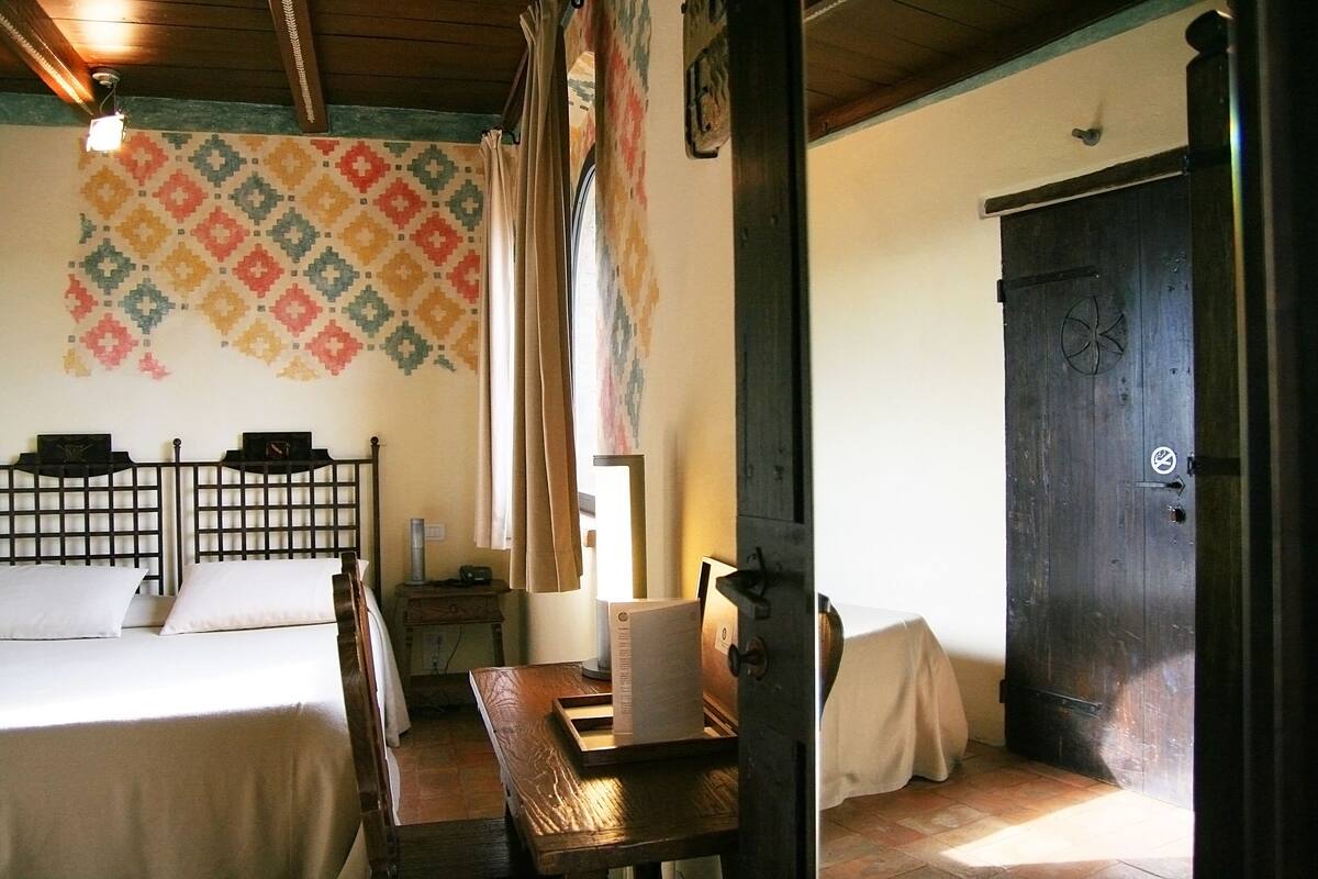 A room with a bed, a wooden table, and a wardrobe.