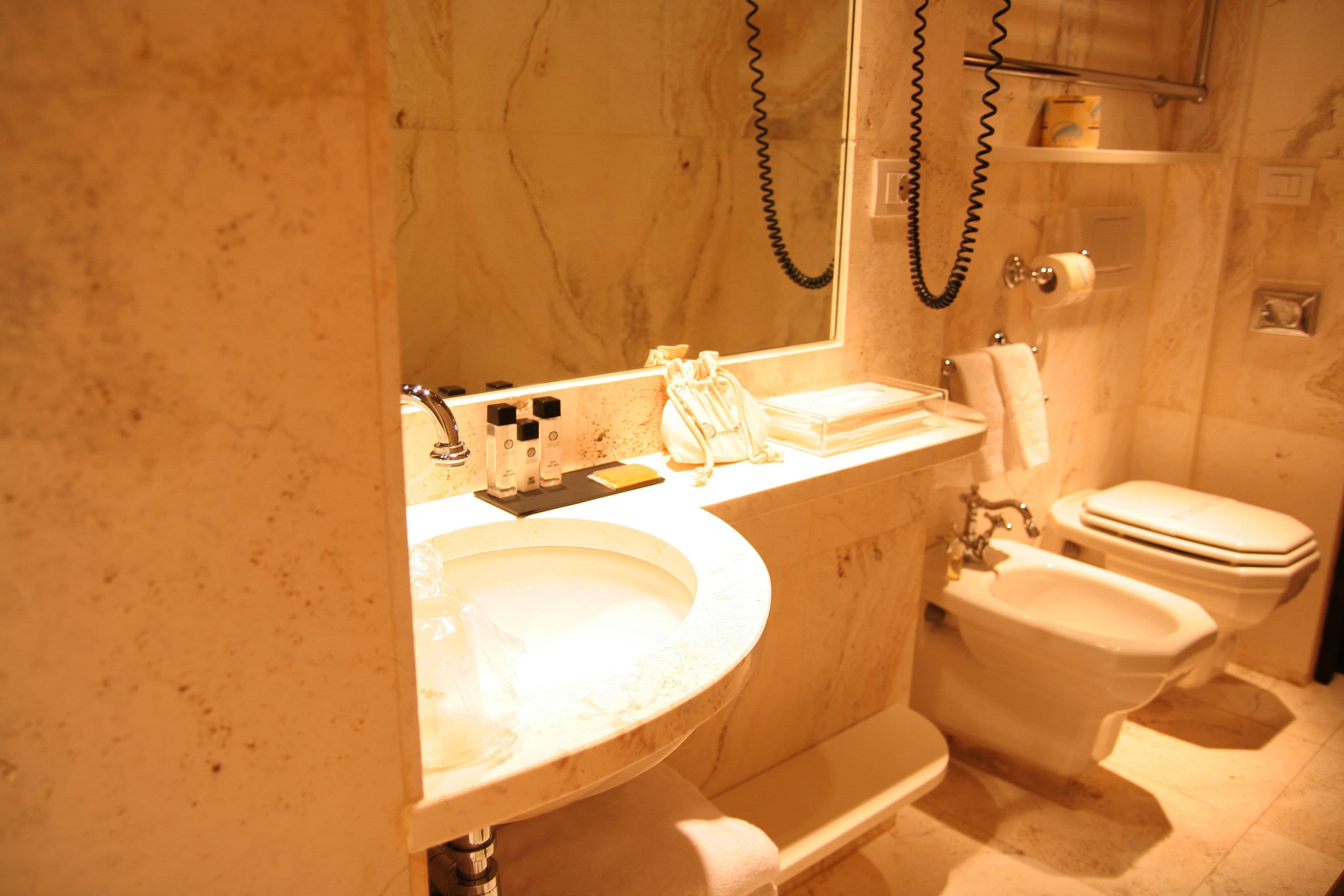 Une salle de bain équipée d’un lavabo, de toilettes et d’un bidet.