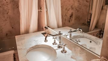 A bathroom with a marble sink, a mirror, and a shower curtain.
