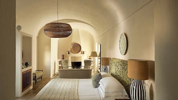 Un dormitorio amplio con una cama grande, una lámpara colgante y una chimenea.