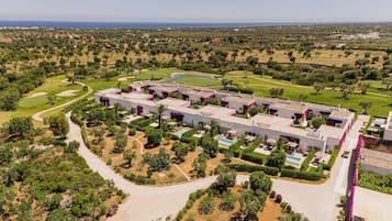 Ein großes Hotel mit mehreren Gebäuden, einem Golfplatz und einem Schwimmbad.
