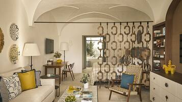 A spacious living room with a high arched ceiling, a coffee table, a sofa, and a dining area.