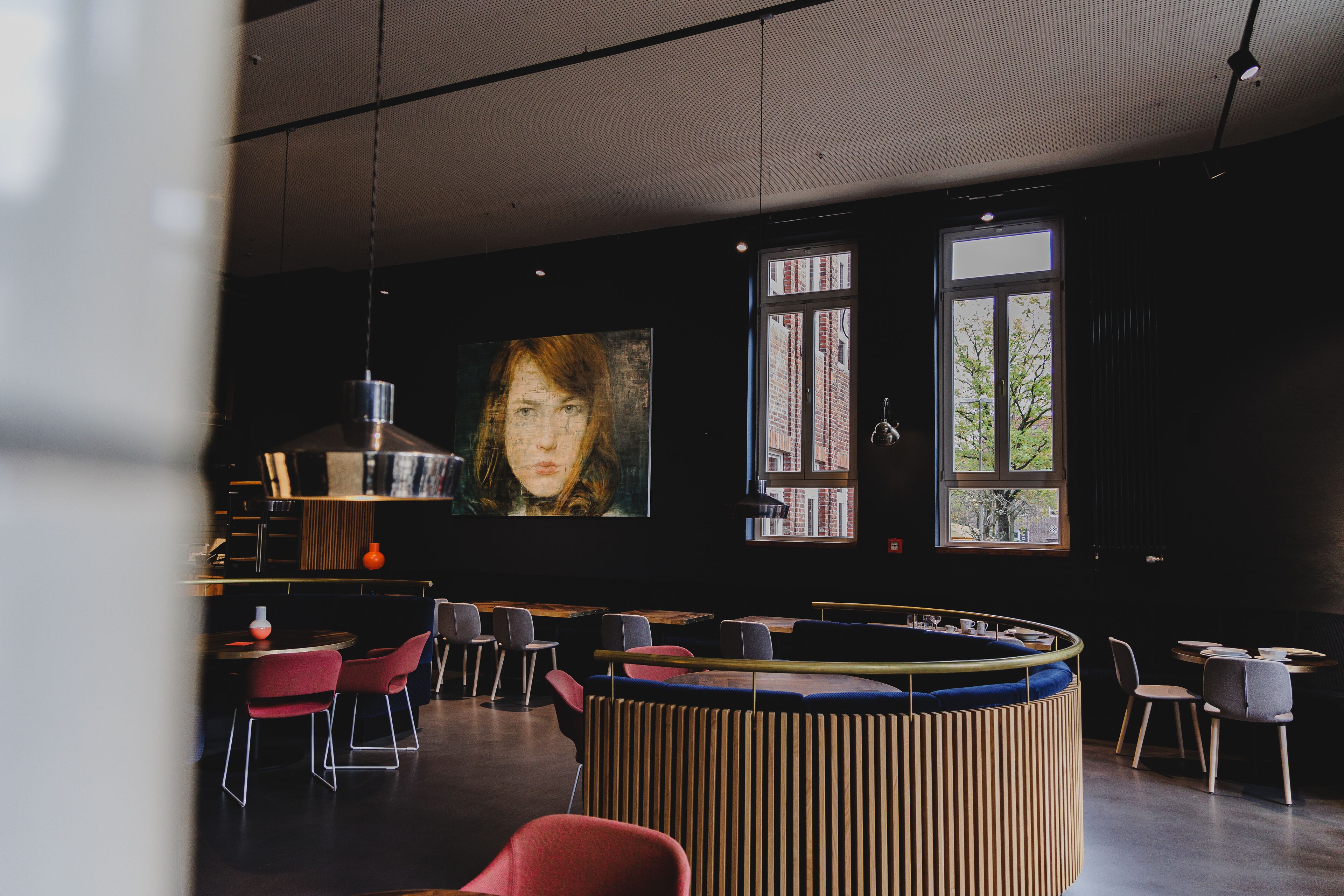 Een modern interieur met een bar, zitplaatsen en grote ramen.