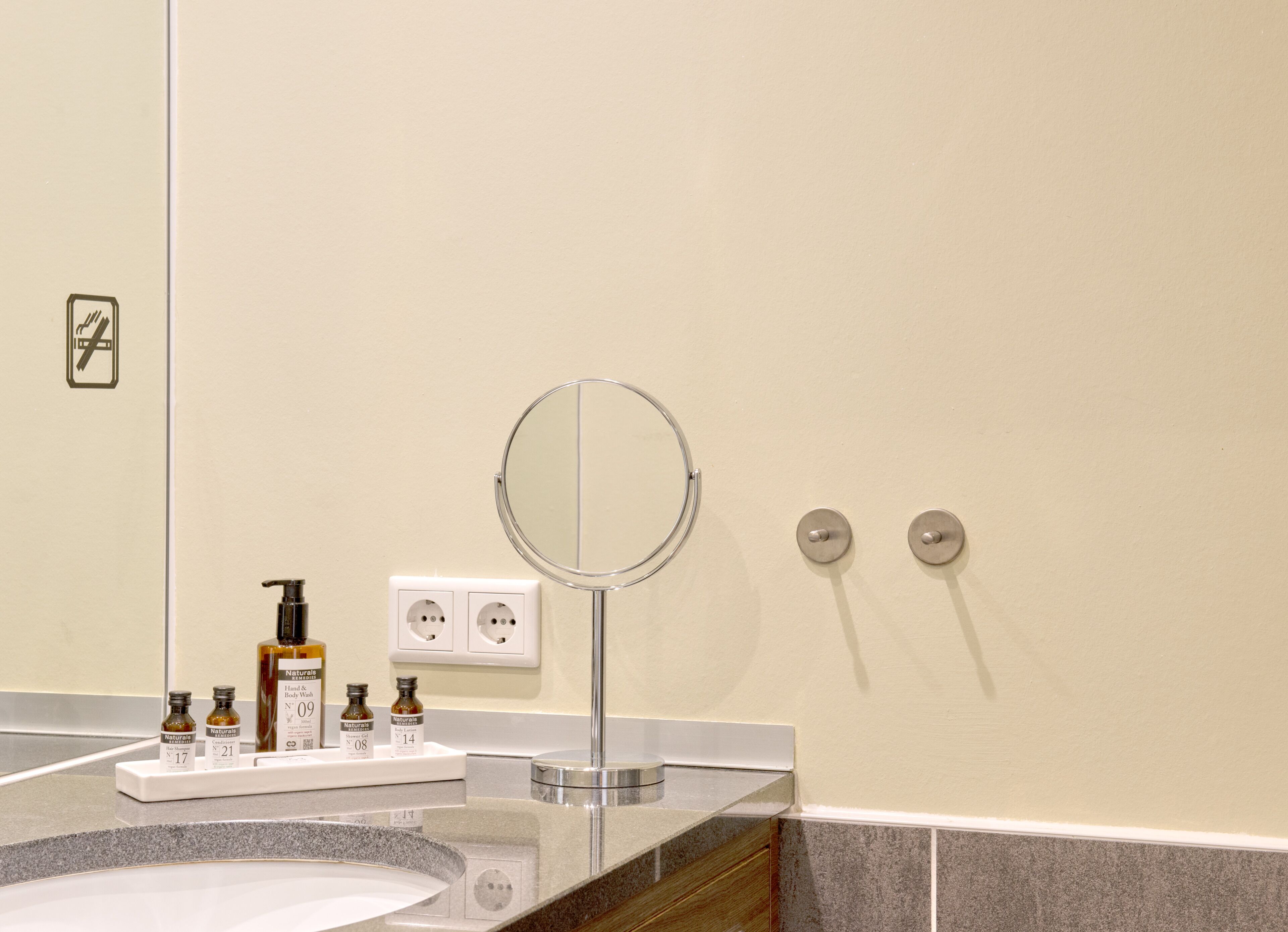 A bathroom with a sink, mirror, and toiletries.