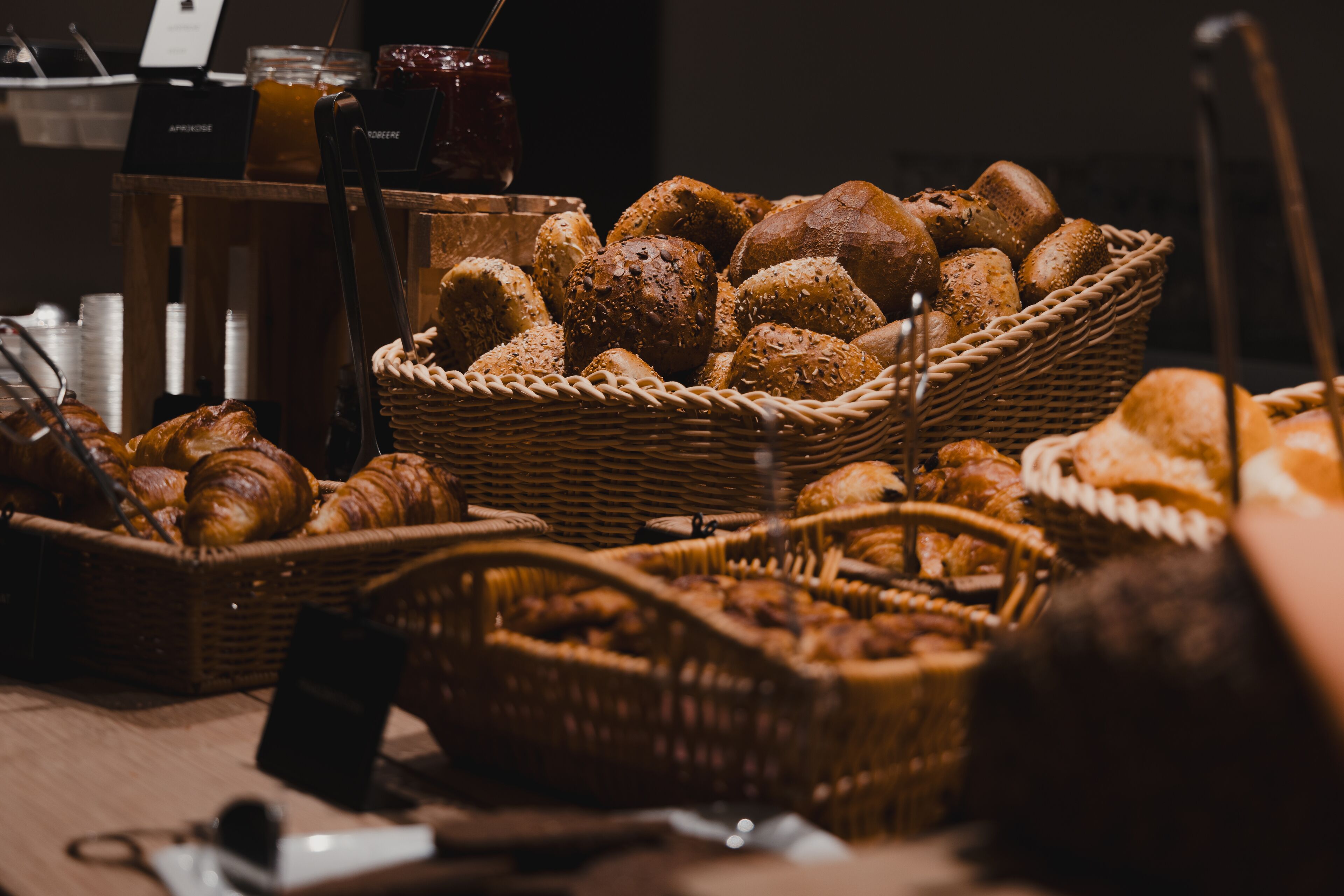 A variety of breads and pastries in wicker baskets.