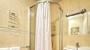 A bathroom with a glass shower enclosure, a white sink, and a toilet. - Parkwood at Marble Arch (London)