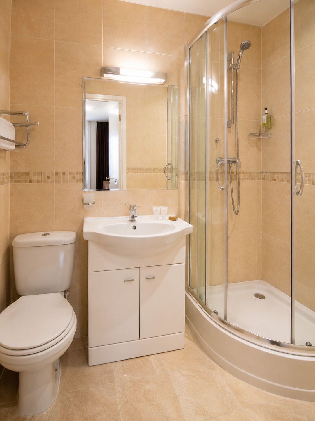 A bathroom with a toilet, sink, and glass-enclosed shower.
