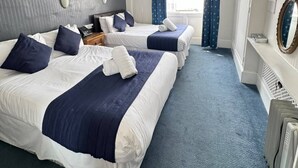 A hotel room with two beds, a large window with curtains, a desk with a mirror, and a radiator. - Parkwood at Marble Arch (London)