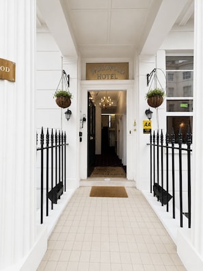 A hotel entrance with a sign reading 'Parkwood Hotel,' a doormat, a chandelier, and a sign indicating a 3-star rating. - Parkwood at Marble Arch (London)