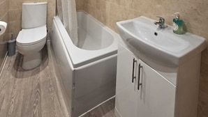 A bathroom with a toilet, bathtub, and sink. - The Countryman Hotel (Camelford)