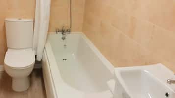 A bathroom with a toilet, a bathtub, and a sink.