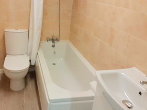 A bathroom with a toilet, a bathtub, and a sink. - The Countryman Hotel (Camelford)