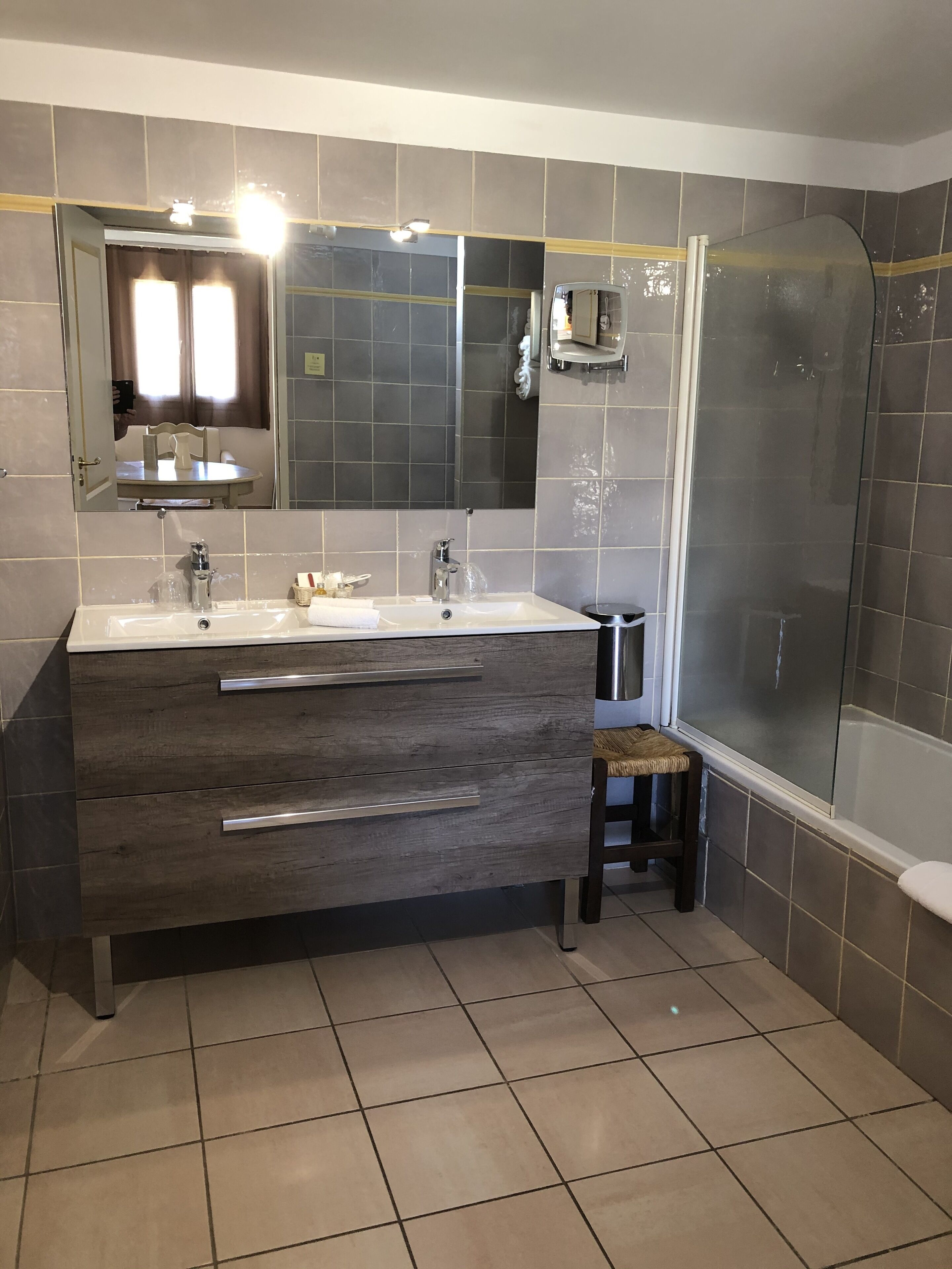 Une salle de bain moderne avec un meuble-lavabo à deux vasques, un grand miroir et une douche à parois de verre.