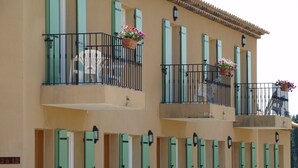 A multi-story building with balconies, each with a railing and potted plants. - Hôtel Terriciaë aux portes de Maussane les Alpilles (Mouries)