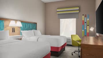 Habitación de hotel con dos camas, un escritorio, una silla, un televisor y una ventana con vistas.