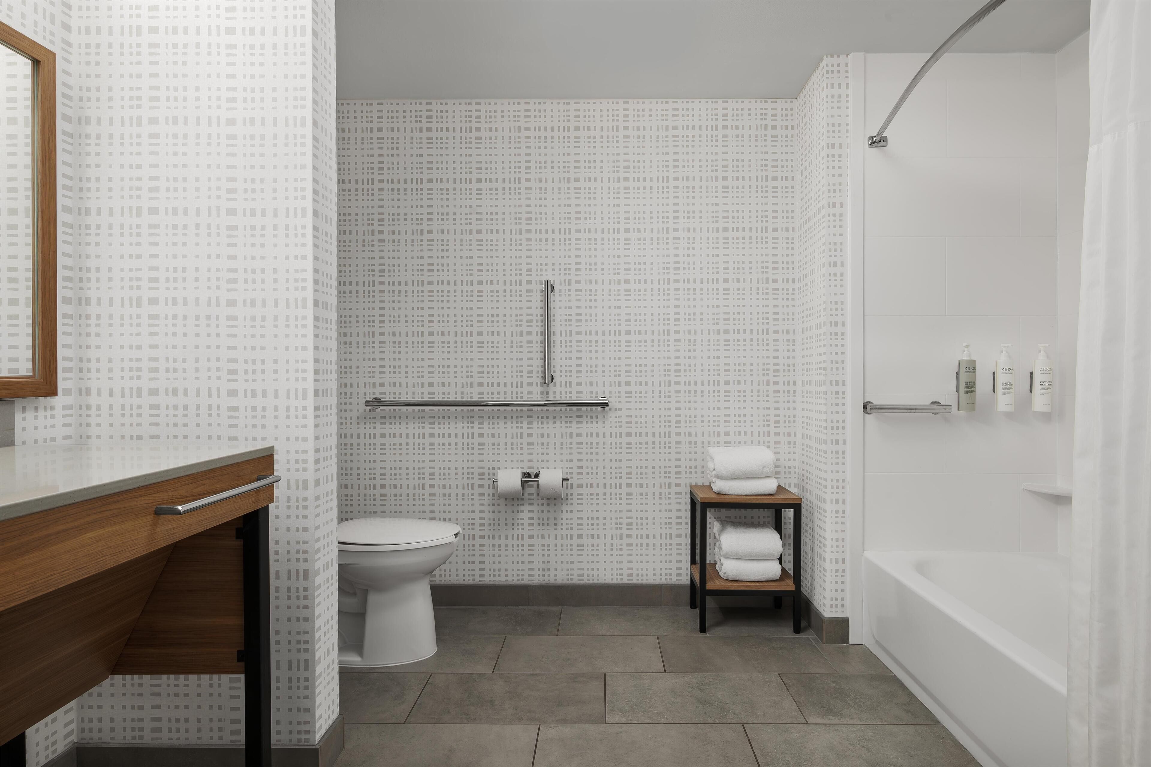 Une salle de bain moderne équipée de toilettes, d’un lavabo et d’une baignoire.