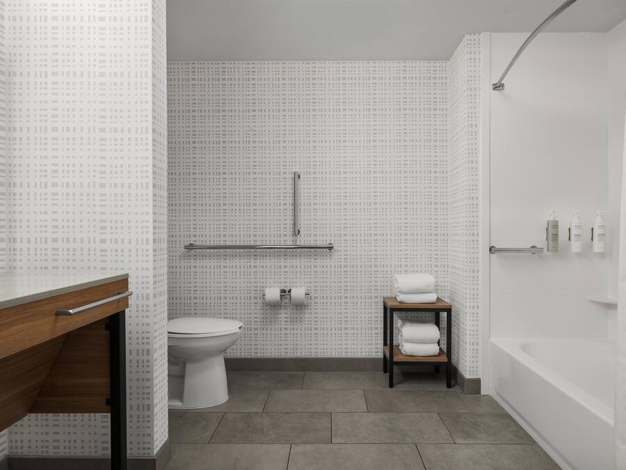 Une salle de bain moderne équipée de toilettes, d’un lavabo et d’une baignoire.