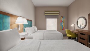 A hotel room with two beds, a desk, a chair, a lamp, a mirror, and a window with blinds. - Hampton Inn Leesburg/Tavares (Leesburg)