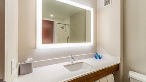 A bathroom with a white sink, a mirror, and a shower. - Holiday Inn Express Haskell - Wayne Area by IHG (Wanaque)