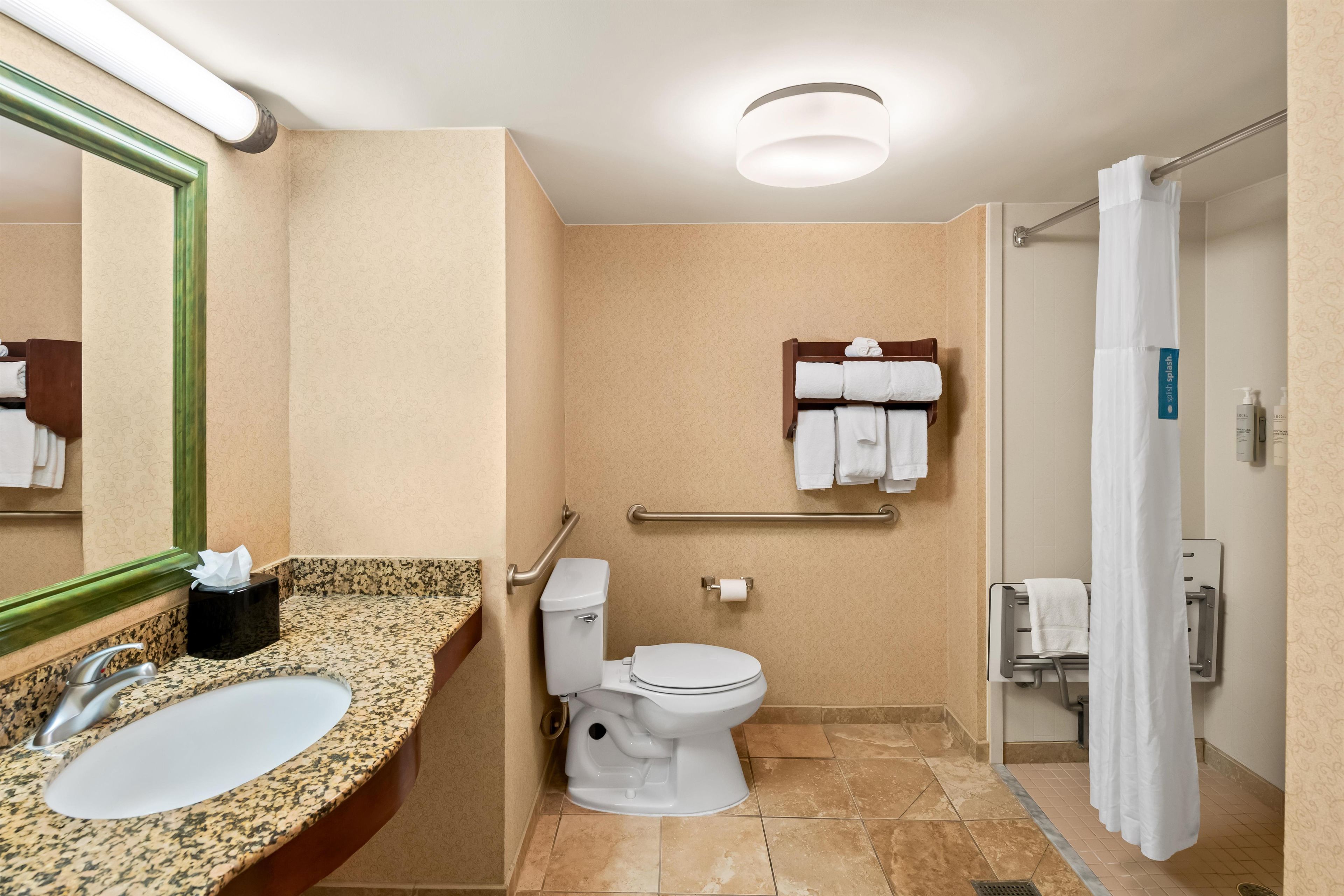 A bathroom with a sink, toilet, and shower area.