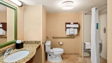 A bathroom with a sink, toilet, and shower area.