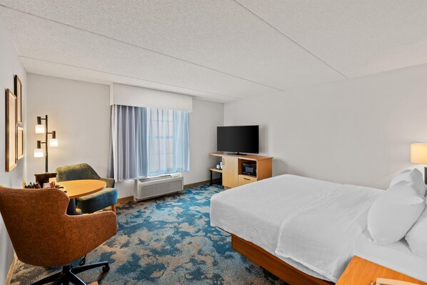 A hotel room with a bed, a desk, a chair, a television, and a window with curtains. - Hampton Inn & Suites Williamsburg-Central (Williamsburg)