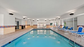 A swimming pool with lounge chairs and a changing room.