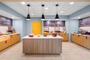 A bakery counter with a central island, a coffee machine, and various food items displayed. - Hampton Inn & Suites Williamsburg-Central (Williamsburg)