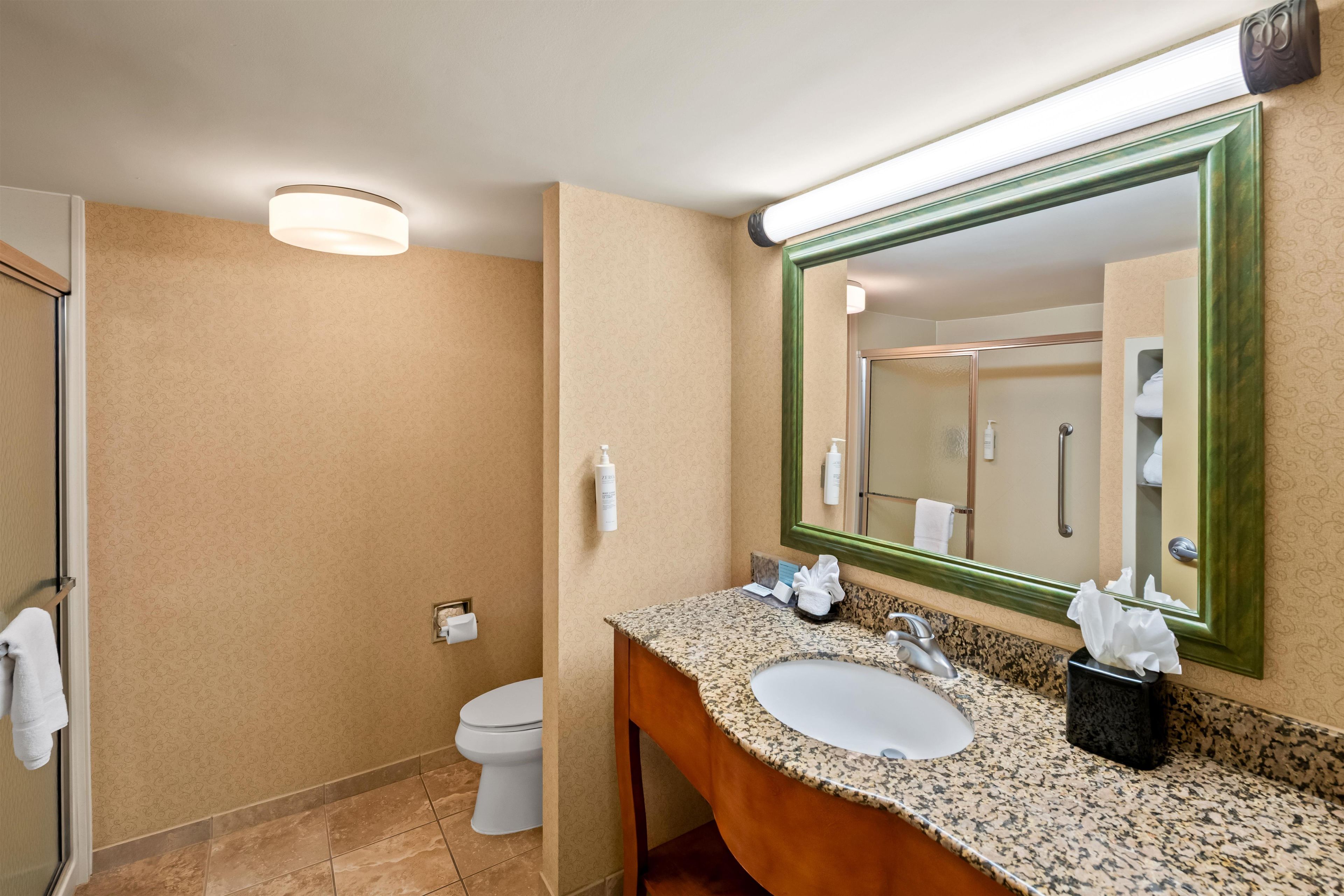 Un baño con lavamanos, espejo y retrete.