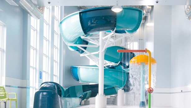 An indoor swimming pool with a water slide and a water fountain. - Best Western Plus Dartmouth Hotel & Suites (Dartmouth)