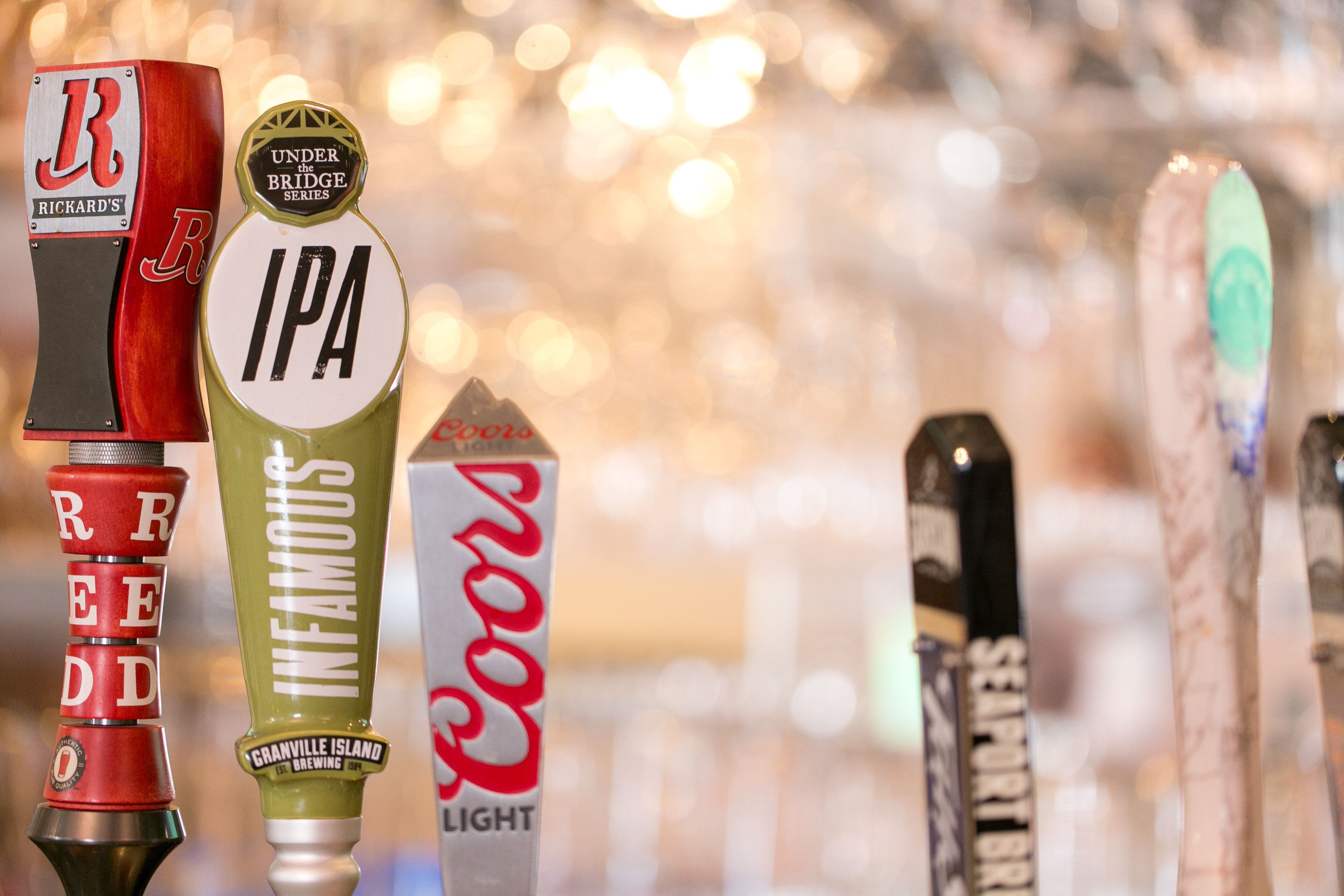 Un bar con varias griferías de cerveza, incluyendo marcas como Richard's, IPA, Infamous, Coors Light y Seafort.