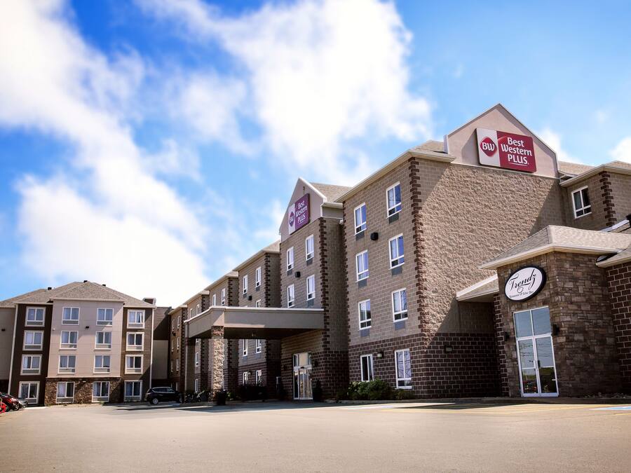 A multi-story hotel with a brick facade, a covered entrance, and a sign indicating it is part of the Best Western Plus chain.