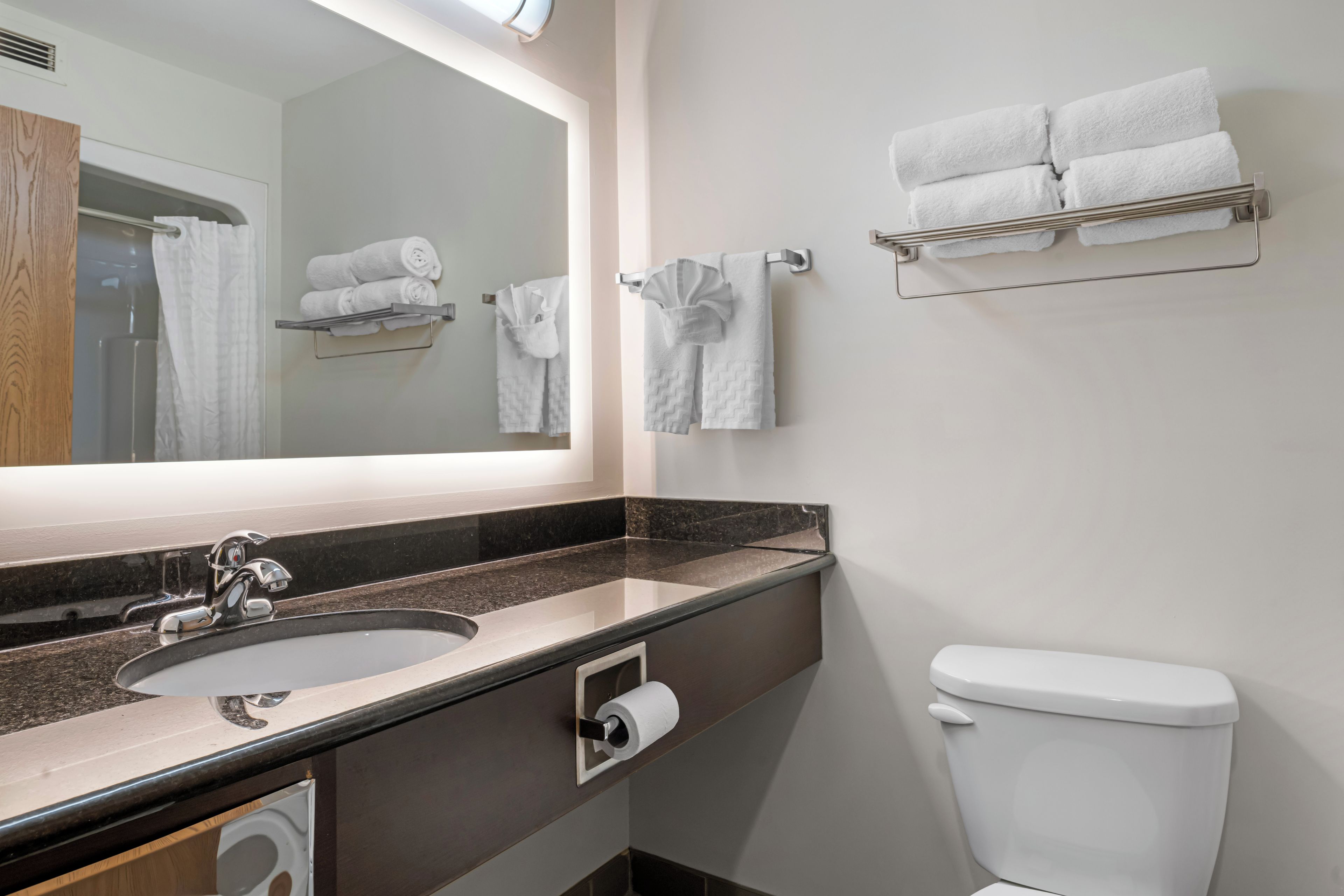 A bathroom with a sink, mirror, towel rack, and toilet.