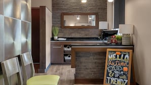 A modern kitchen with a brick wall, pendant lights, a chalkboard sign, and a wooden counter. - Best Western Plus Dartmouth Hotel & Suites (Dartmouth)