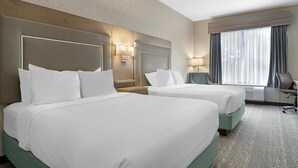 A hotel room with two beds, a desk, a chair, and a large window with curtains. - Best Western Plus Dartmouth Hotel & Suites (Dartmouth)