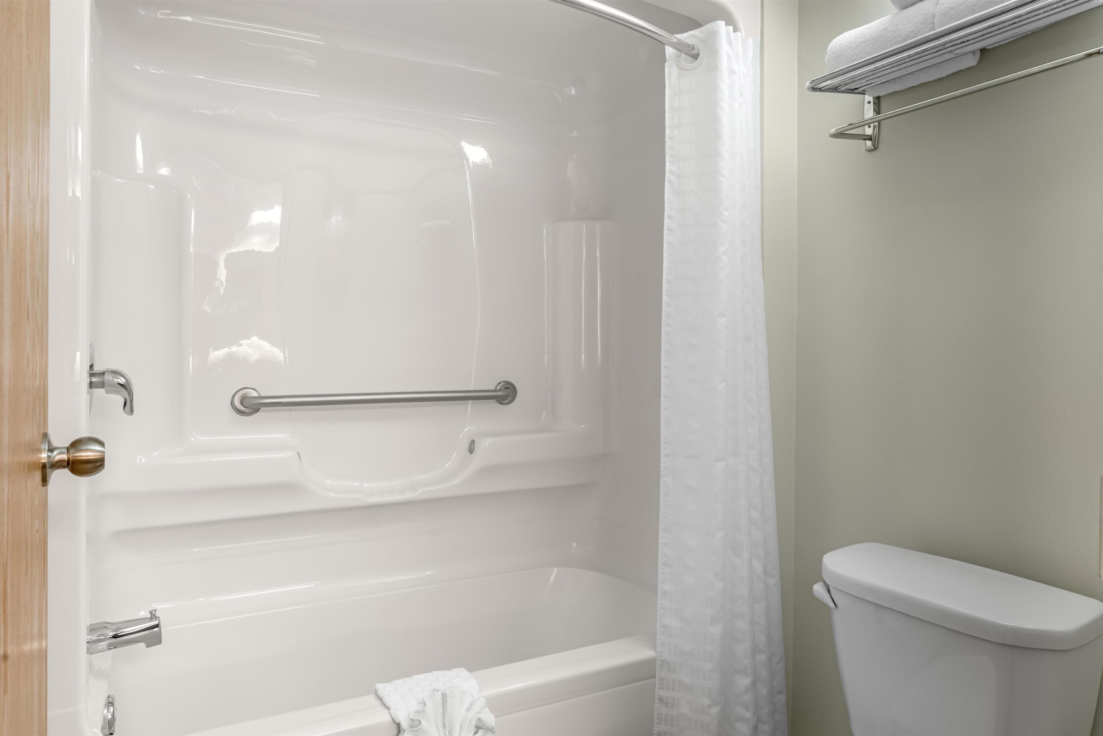 Une salle de bain avec une baignoire, des toilettes et un rideau de douche.