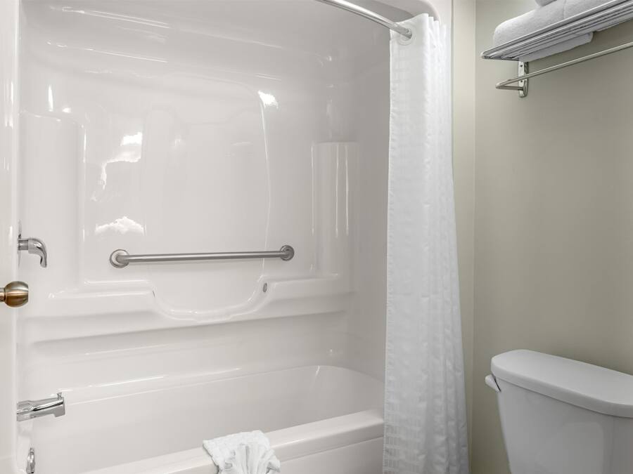 Un baño con bañera, inodoro y cortina de ducha.