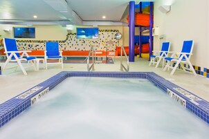 Una piscina techada, sillones reclinables de piscina