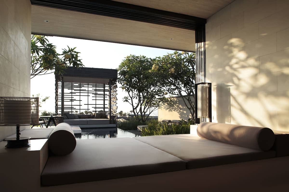 A modern outdoor seating area with a view of a building and trees.