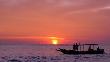 Un barco con pasajeros al atardecer.