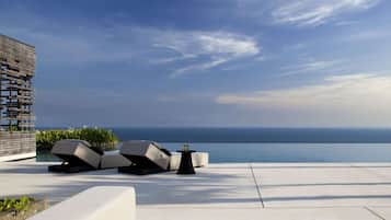 A modern outdoor seating area with a view of the ocean.
