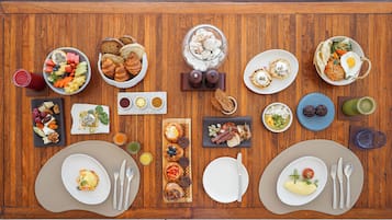 A wooden table with various breakfast items and drinks.
