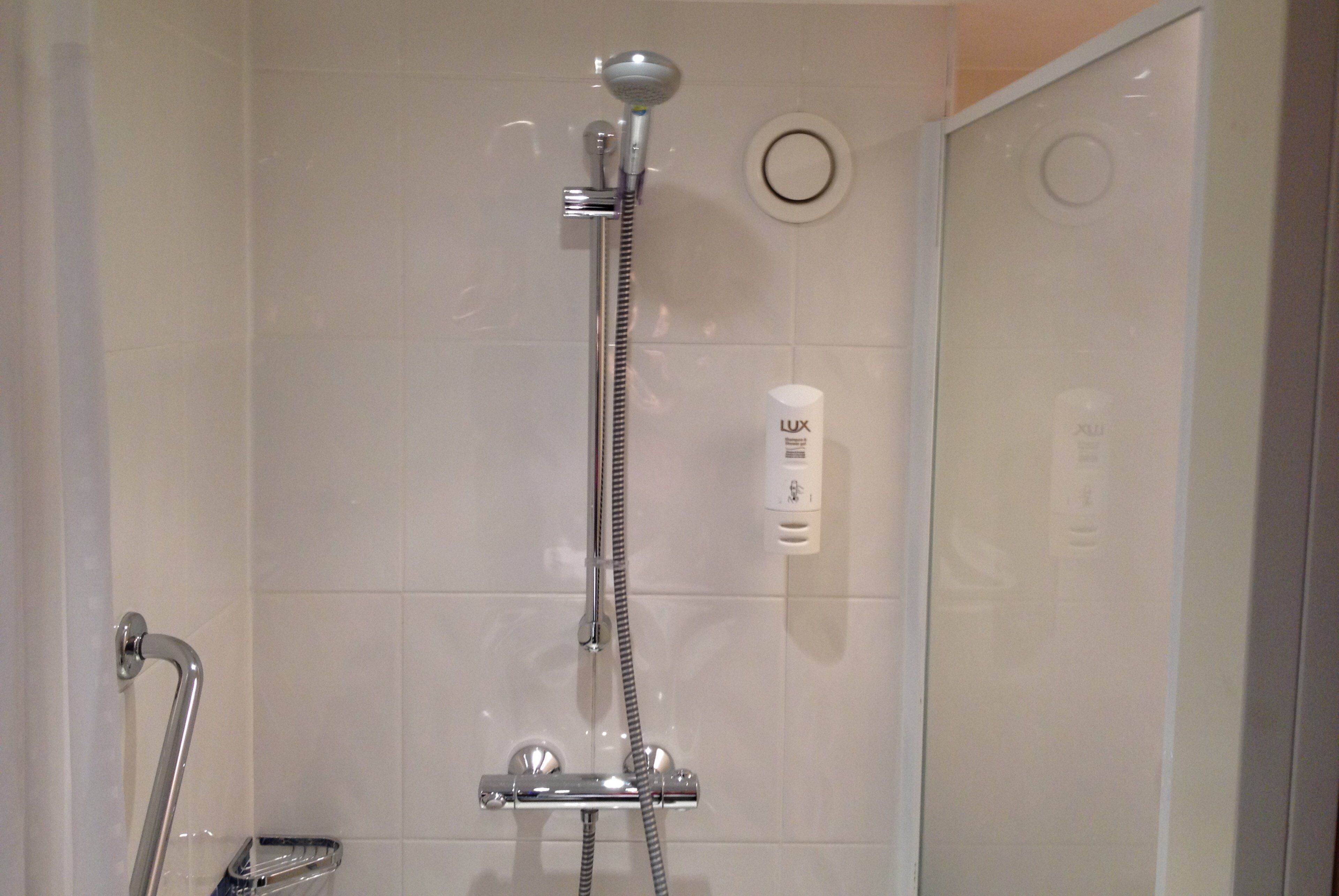 Ducha con cabezal de ducha de mano, control de ducha de mano y control de pared.