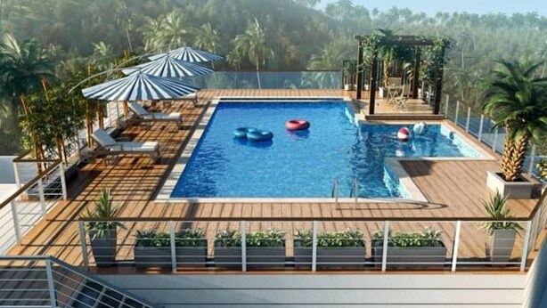 Une piscine sur le toit, avec une terrasse en bois, des chaises longues et des parasols.