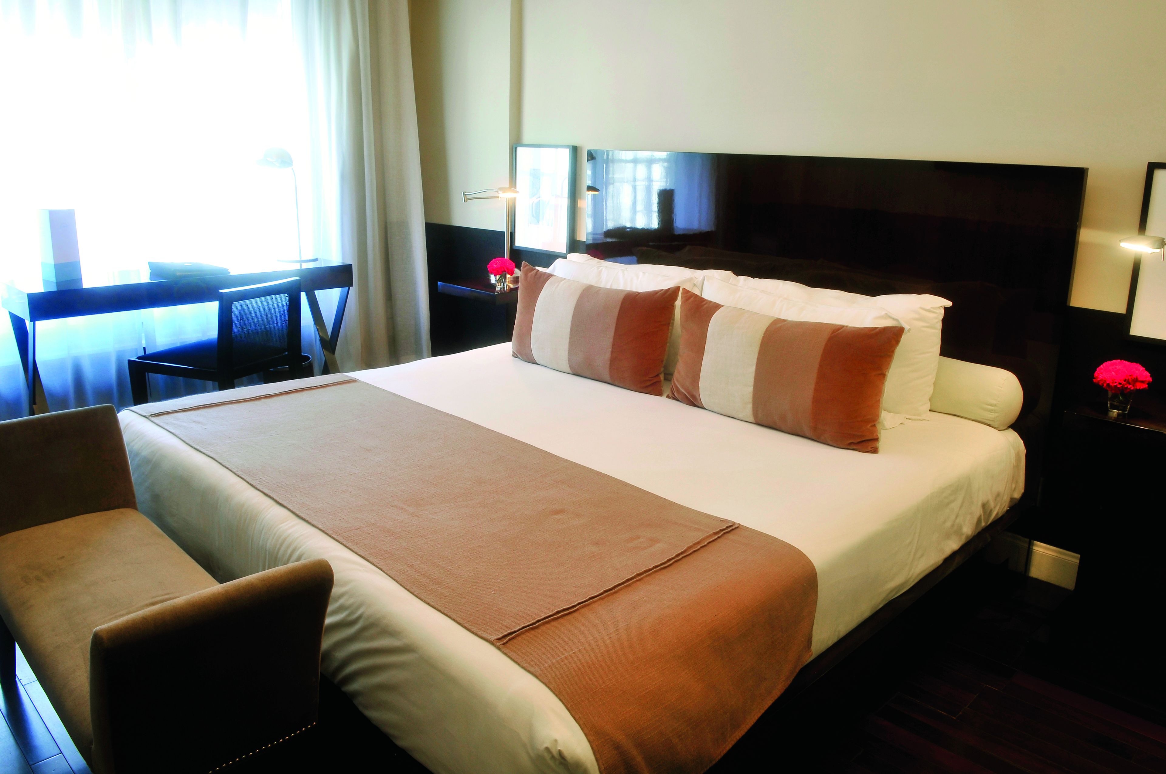 Una habitación de hotel con una cama grande, un escritorio y una silla.