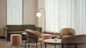 A modern living room with a green sofa, two patterned armchairs, a round coffee table, and a floor lamp. - DoubleTree by Hilton Sheffield City (Sheffield)