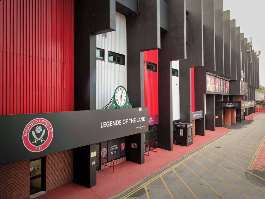 Un edificio moderno con un reloj destacado y señalización que indica “Legends of the Lane”.