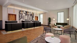 A modern hotel lobby with a reception desk, seating area, and large windows. - DoubleTree by Hilton Sheffield City (Sheffield)